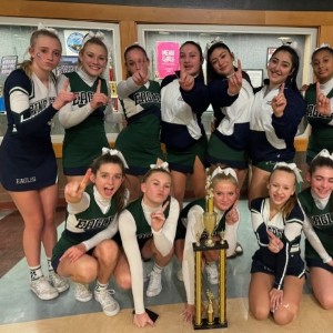 Cheerleaders with trophy holding up pointer fingers to indicate #1